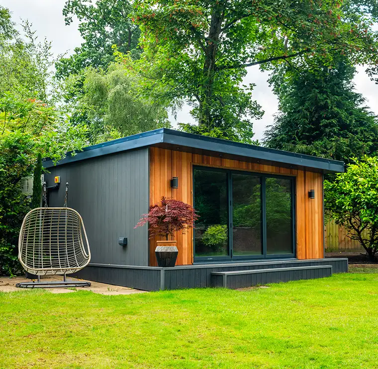 Grey and cedar garden room on a landscaped lawn