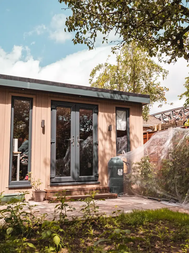 Composite garden room with french doors on a sunny lawn