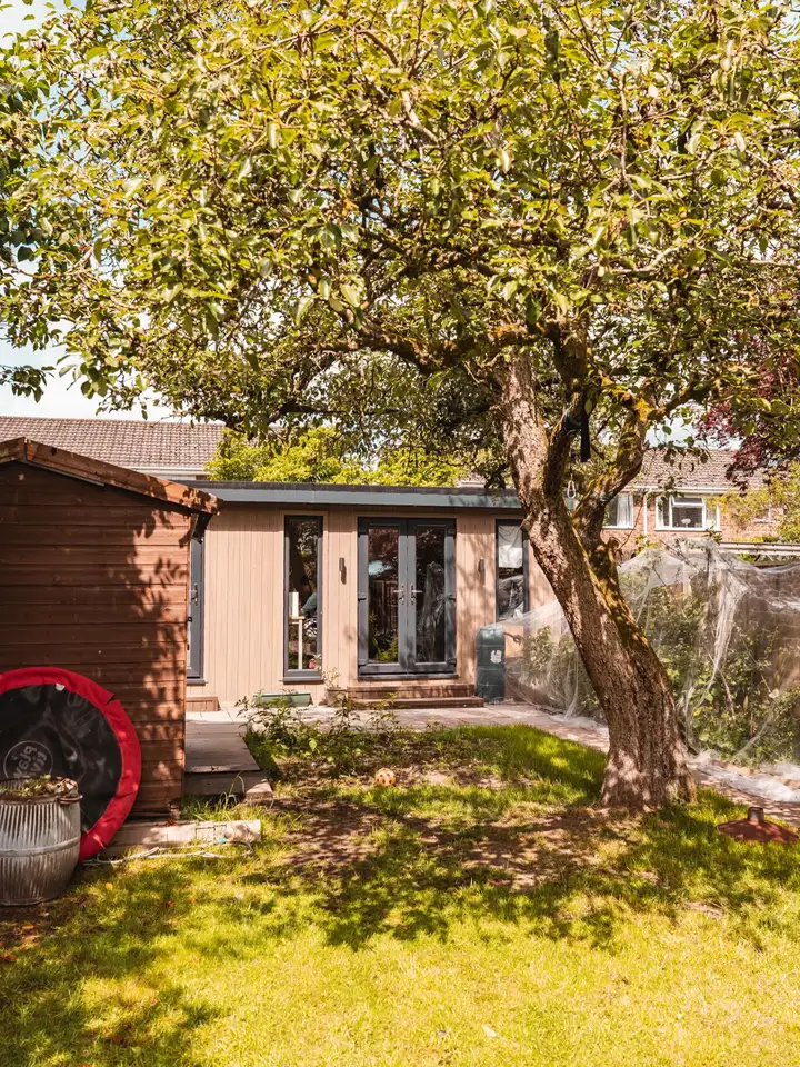 Garden room beneath a mature tree in a North West garden