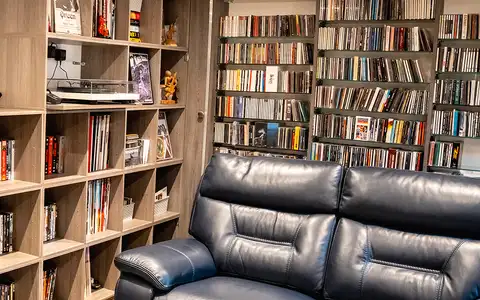 Garden den interior with bookshelves and recliner
