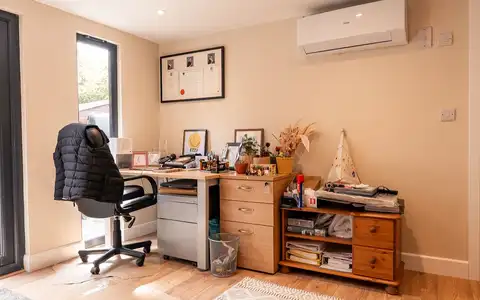 Inside an Elevate garden office with desk and shelving