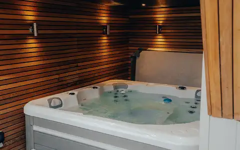 Garden spa room interior with hot tub and timber walls